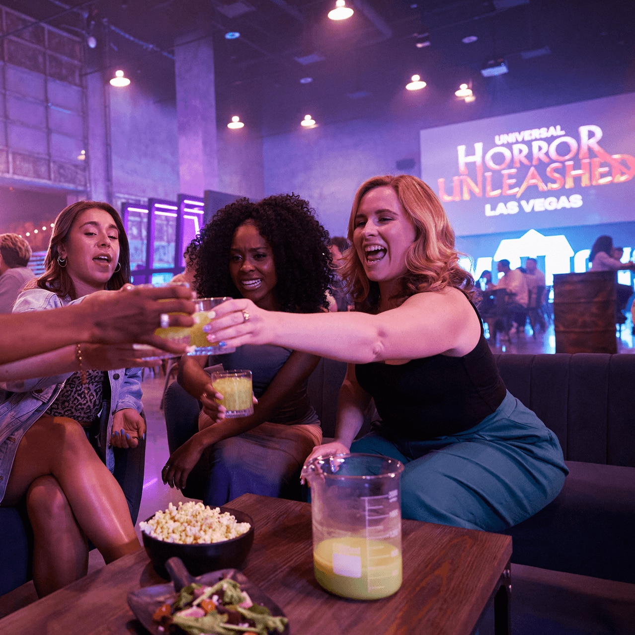 Friends sharing a toast in a themed Universal Horror Unleashed bar